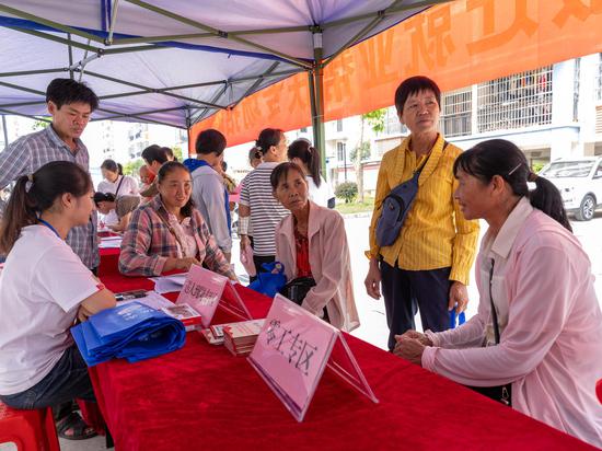 图为驻村队员向村民推荐就业。蓝卫北 摄